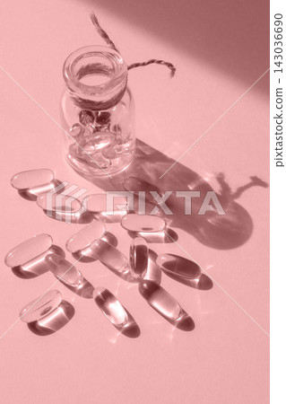 Pills and glass pill bottle on pink background. Big tablets. Omega 3 capsules. Close up, top view. Health care concept. Healthy every day fatty acids nutritional supplement dosage. Flat lay 143036690