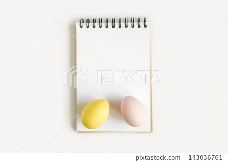Notebook with Easter Eggs. Spiral notepad on spring white background. Top view of open writing pad with blank page, office flat lay. Easter Mock Up 143036761