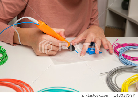 Teen Girl Using 3d Pen. Printing with Colored Plastic Wire Filament. Child making a House, drawing with 3D pen. Artwork, Robotics. STEAM, STEM education. Modern Technologies. Play and study at home 143037587