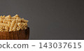 Gluten Free Cornmeal Pasta in wooden Bowl. Spiral Raw Macaroni from Blend of Corn and Rice flour. Close Up, Front View. Uncooked Bucati Pasta. Food Background. Horizontal banner with space for text 143037615