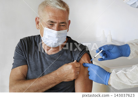 Doctor Vaccinating Senior Man In Clinic. Older People Vaccination. Doctor Giving Monkeypox or COVID Vaccine Injection to Mature Man In Face Mask. Protection of Elderly Patient. Old Man in Hospital Doctor Vaccinating Senior Man In Clinic. Older People Vaccination. Doctor Giving Monkeypox or COVID Vaccine Injection to Mature Man In Face Mask. Protection of Elderly Patient. Old Man in Hospital 143037623