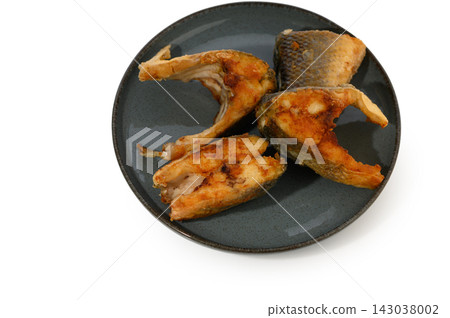 Commercial stock photo of fried fish steak portions arranged on a dark plate Commercial stock photo of fried fish steak portions arranged on a dark plate 143038002