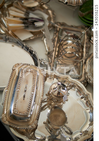 Vintage silverware. Antique silver teapots, creamer and other utensils at street flea market Vintage silverware. Antique silver teapots, creamer and other utensils at street flea market 143038215