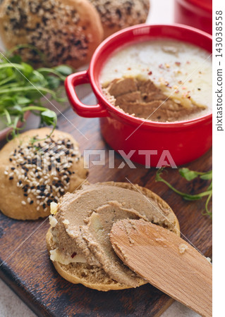 Gourmet Liver Pate Appetizer with Sesame Seed Bagels and and Fresh Pea Shoots on Rustic Wooden Board Gourmet Liver Pate Appetizer with Sesame Seed Bagels and and Fresh Pea Shoots on Rustic Wooden Board 143038558