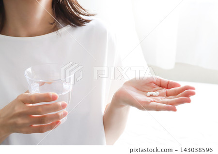 一名女子手捧水和藥品。 一名女子手捧水和藥品。 143038596