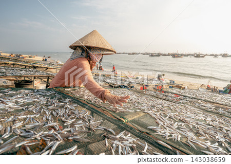 在海邊將魚擺放在晾曬架上。 在海邊將魚擺放在晾曬架上。 143038659