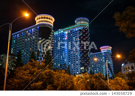 Modern buildings illuminated at night along the Batumi Boulevard seaside promenade on the Black Sea coast in Batumi, Georgia Modern buildings illuminated at night along the Batumi Boulevard seaside promenade on the Black Sea coast in Batumi, Georgia 143038729