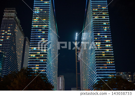 Modern buildings illuminated at night along the Batumi Boulevard seaside promenade on the Black Sea coast in Batumi, Georgia 143038733