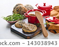 Gourmet Liver Pate Appetizer with Sesame Seed Bagels and and Fresh Pea Shoots on Rustic Wooden Board 143038943