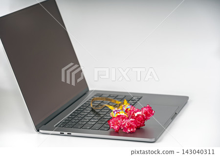 Close-up of a colorful floral garland placed on a laptop keyboard, following the Thai custom of paying respect to belongings for good fortune and prosperity Close-up of a colorful floral garland placed on a laptop keyboard, following the Thai custom of paying respect to belongings for good fortune and prosperity 143040311