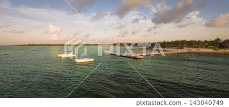 Pier and boat moored at sunrise over the Caribbean sea in Playa del Carmen Pier and boat moored at sunrise over the Caribbean sea in Playa del Carmen 143040749