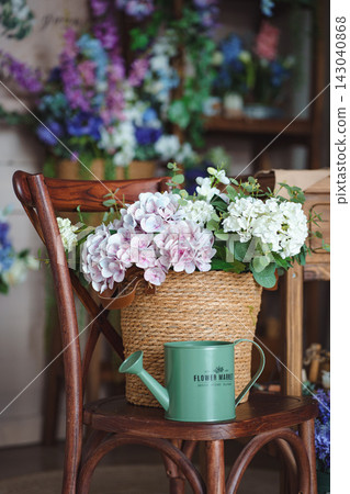 Rustic cottagecore still life with hydrangea basket and metal watering can Rustic cottagecore still life with hydrangea basket and metal watering can 143040868