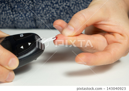 Measuring blood glucose levels, sugar test with a home glucometer Measuring blood glucose levels, sugar test with a home glucometer 143040923