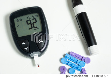 Digital glucometer showing normal blood sugar result on white background 143040926