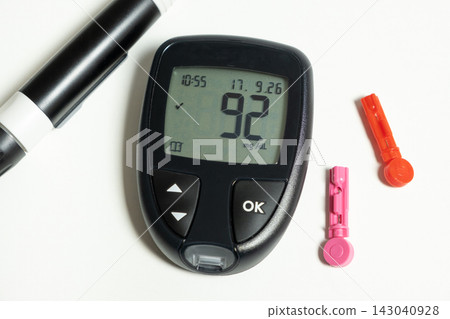Digital glucometer showing normal blood sugar result on white background 143040928