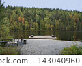 A wooden dock extends into a serene lake 143040960