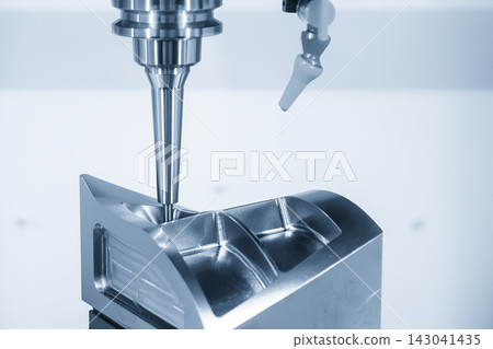 5-axis CNC milling machine finishing a metal mold part with a ball nose end mill in blue tone 5-axis CNC milling machine finishing a metal mold part with a ball nose end mill in blue tone 143041435