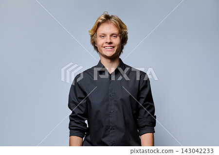 Smiling young man looking at camera in studio portrait Smiling young man looking at camera in studio portrait 143042233