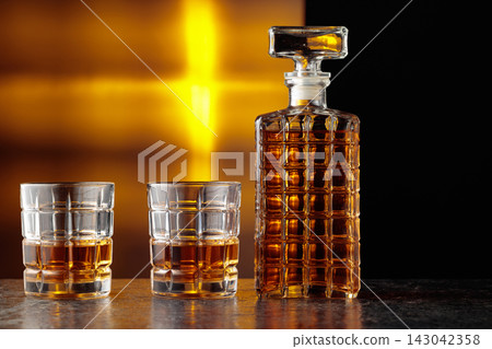 Glasses and decanter of whisky on a black stone table. Glasses and decanter of whisky on a black stone table. 143042358