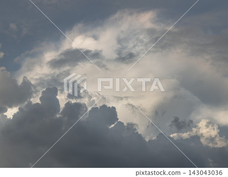 An extraordinary atmospheric display where nature elements mirror a grand canyon landscape. Deep, dark, jagged cloud banks form rugged "ridgelines" along the foreground, carving out a sweeping. An extraordinary atmospheric display where nature elements mirror a grand canyon landscape. Deep, dark, jagged cloud banks form rugged "ridgelines" along the foreground, carving out a sweeping. 143043036