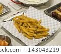 Crispy Seasoned French Fries on Checkered Paper in a Metal Tray 143043219