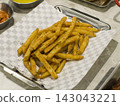 Crispy Seasoned French Fries on Checkered Paper in a Metal Tray 143043221