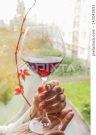 Cozy autumn lifestyle concept with a glass of red wine on a rainy day Cozy autumn lifestyle concept with a glass of red wine on a rainy day 143043691