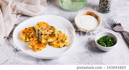 Appetizing fritters made from boiled eggs, green onions, and cheese, on a plate on the table web banner Appetizing fritters made from boiled eggs, green onions, and cheese, on a plate on the table web banner 143043803