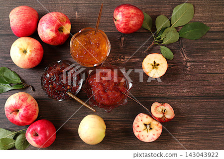 Fresh apple butter or jam made from various apple varieties.An assortment of preserves, fruit butters and fresh fruit purees arranged on wooden kitchen counter. home canning concept, banner Fresh apple butter or jam made from various apple varieties.An assortment of preserves, fruit butters and fresh fruit purees arranged on wooden kitchen counter. home canning concept, banner 143043922