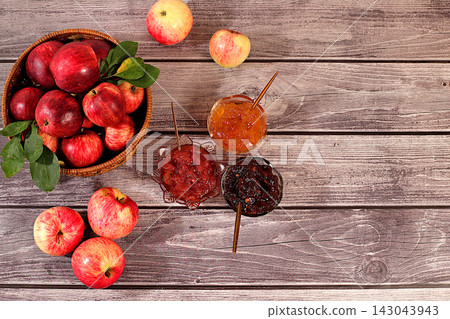 An assortment of preserves, fruit butters and fresh fruit purees arranged on wooden kitchen counter.Fresh apple butter or jam made from various apple varieties. home canning concept, banner An assortment of preserves, fruit butters and fresh fruit purees arranged on wooden kitchen counter.Fresh apple butter or jam made from various apple varieties. home canning concept, banner 143043943