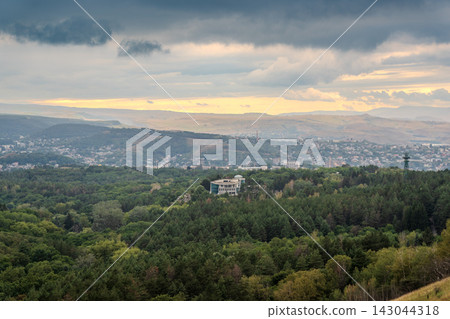 View of the mountains and Kislovodsk from the observation decks of the Kislovodsk Park. Evening sunset over the mountains of Kislovodsk. View of the mountains and Kislovodsk from the observation decks of the Kislovodsk Park. Evening sunset over the mountains of Kislovodsk. 143044318