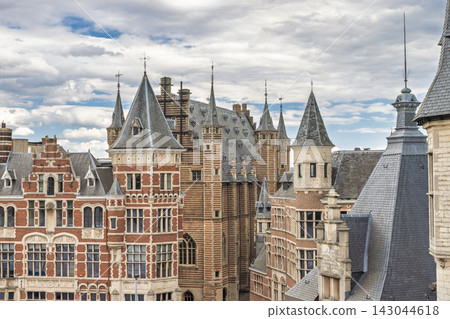 Antwerp town in Belgium, Europe. Historic European Cityscape with Traditional Architecture, Intricate Roofs, and Ornate Towers Against a Cloudy Sky Antwerp town in Belgium, Europe. Historic European Cityscape with Traditional Architecture, Intricate Roofs, and Ornate Towers Against a Cloudy Sky 143044618