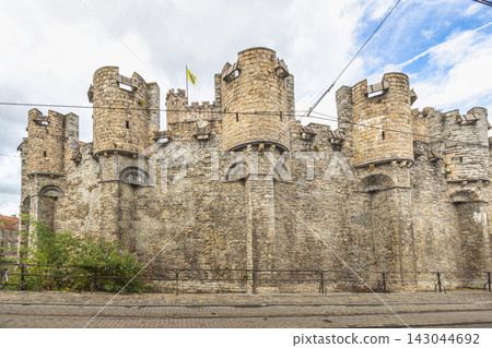 Gravensteen, a medieval castle in the city of Ghent in Belgium, Europe. Ancient Stone Fortress with Defensive Towers Standing Tall Against a Cloudy Sky in European City Gravensteen, a medieval castle in the city of Ghent in Belgium, Europe. Ancient Stone Fortress with Defensive Towers Standing Tall Against a Cloudy Sky in European City 143044692