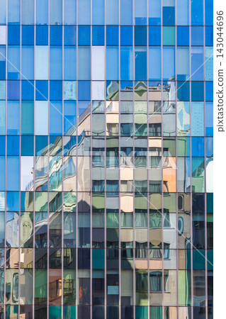 Modern glass facade with vibrant reflections of an older building creating an abstract and dynamic urban texture. City of Brussels in Belgium, Europe. 143044696