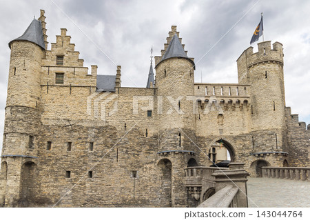 Antwerp town in Belgium, Europe. Het Steen, Grand Medieval Castle Exterior with Towering Walls and Turrets Under a Cloudy Sky, Reflecting Timeless Architecture and History Antwerp town in Belgium, Europe. Het Steen, Grand Medieval Castle Exterior with Towering Walls and Turrets Under a Cloudy Sky, Reflecting Timeless Architecture and History 143044764