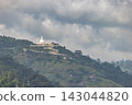 Majestic Temple Perched on a Lush Green Tropical Mountain Landscape Under an Overcast Sky with Winding Path. View from Little Adam's Peak in Sri Lanka. 143044820
