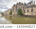 Ghent town in Belgium, Europe. Saint Michael's Church. Historic Stone Buildings Line a Serene Canal Under a Cloudy Sky, Reflecting European Architectural Heritage and Tranquil Waterscape 143044823