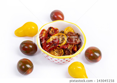 Fresh yellow and dark and dried tomatoes on the white background Fresh yellow and dark and dried tomatoes on the white background 143045158