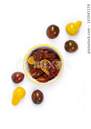 Fresh yellow and dark and dried tomatoes on the white background Fresh yellow and dark and dried tomatoes on the white background 143045159