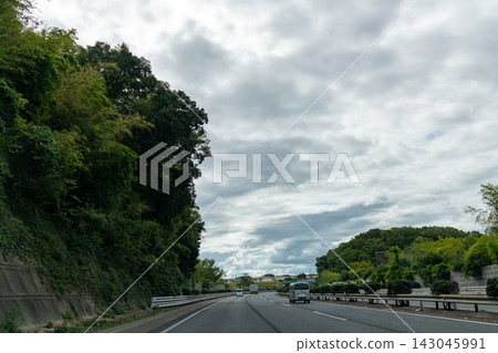 背景圖片為高速公路,天空湛藍,白雲朵朵。 背景圖片為高速公路,天空湛藍,白雲朵朵。 143045991