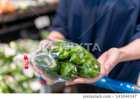 Hands of shoppers choosing bell peppers at the supermarket Hands of shoppers choosing bell peppers at the supermarket 143046347