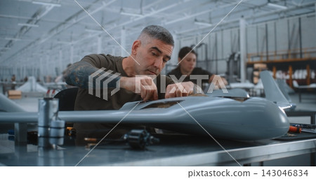 Skilled Specialist Installs Electronic Hardware, Cylindrical Unit and Connects Wiring Inside Drone Skilled Specialist Installs Electronic Hardware, Cylindrical Unit and Connects Wiring Inside Drone 143046834