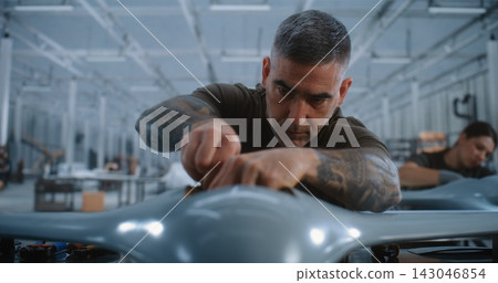 Male Technician Connecting Drone Electronics on High Tech Production Line With Female Colleague Male Technician Connecting Drone Electronics on High Tech Production Line With Female Colleague 143046854