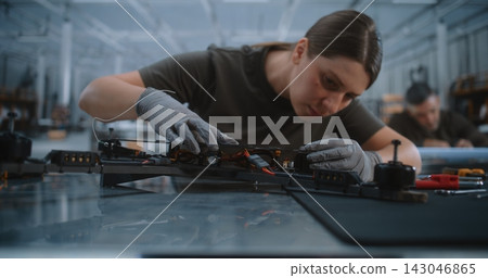 Female Technician Assembling Quadcopter in Drone Manufacturing Plant Female Technician Assembling Quadcopter in Drone Manufacturing Plant 143046865