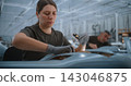 Female Technician Installing Circuit Boards in Fixed Wing UAV During Advanced Electronics Assembly 143046875