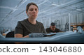 Confident Female Drone Specialist Looking at Camera in Aerospace Factory 143046880