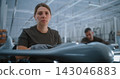 Confident Female Drone Specialist Looking at Camera in Aerospace Factory 143046883