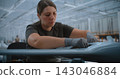 Female Technician Installing Circuit Boards in Fixed Wing UAV During Advanced Electronics Assembly 143046884