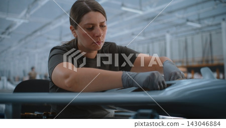 Female Technician Installing Circuit Boards in Fixed Wing UAV During Advanced Electronics Assembly Female Technician Installing Circuit Boards in Fixed Wing UAV During Advanced Electronics Assembly 143046884