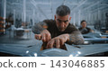Technician Installing Electronic Components and Connecting Wiring Inside Fixed Wing Drone 143046885